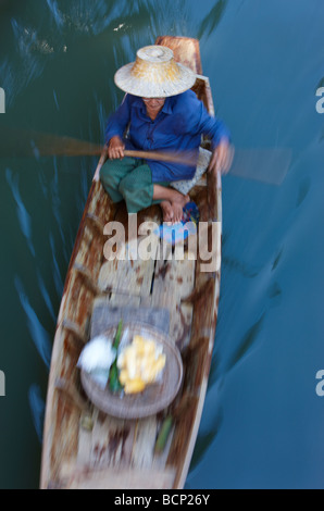 eine Frau paddeln ein Boot zu den schwimmenden Markt in Damnoen Saduak, nr Bangkok, Thailand Stockfoto
