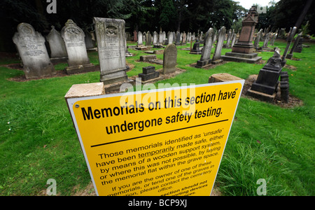 EINE PRÜFUNG SICHERHEITSHINWEIS IN EINEM BRITISCHEN FRIEDHOF BESAGT, DASS GEDENKSTÄTTEN SICHERHEITSTESTS UNTERZOGEN HABEN Stockfoto