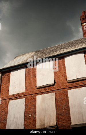 Grüblerische Wolken über Boarded Fenster eines Hauses, die Gebäude im Zentrum von Hereford City Herefordshire England UK Stockfoto