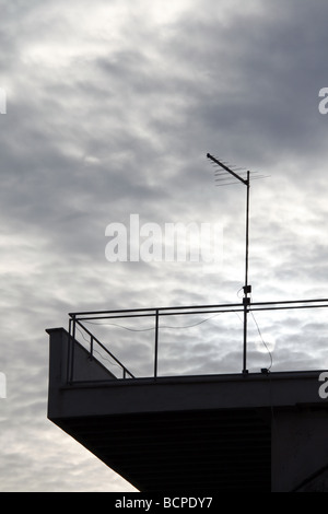eine tv-Antenne auf Eigenschaft Dach gegen düstere Stimmung bewölktem Himmel Stockfoto