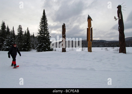 Mann in Schneeschuhen wandern vor den Native Totems in Mont Tremblant Park Laurentians Quebec Stockfoto