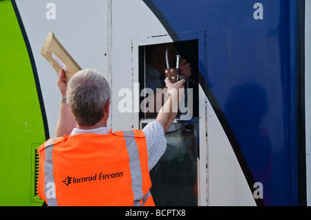 Iarnrod Eireann Stellwerkswärter übergibt einen Stab an dem Lokführer um ihn zu einer einzigen Spur fortsetzen und sammelt Post. Stockfoto