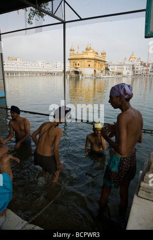 Sikh-Männer Baden in den Gewässern – Sarovar (Wassertank) – um den goldenen Tempel (Sri Harmandir Sahib) Amritsar. Punjab. Indien Stockfoto