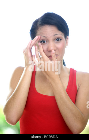 Junge Frau reibt ihre Augenmodell veröffentlicht Stockfoto