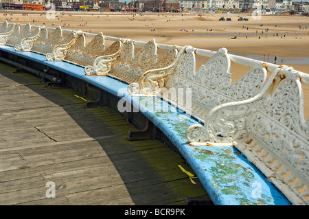 Rostige Sitzgelegenheiten auf zentralen Pier mit Blackpool Strand im Hintergrund Lancashire England UK United Kingdom GB Great Britain Stockfoto