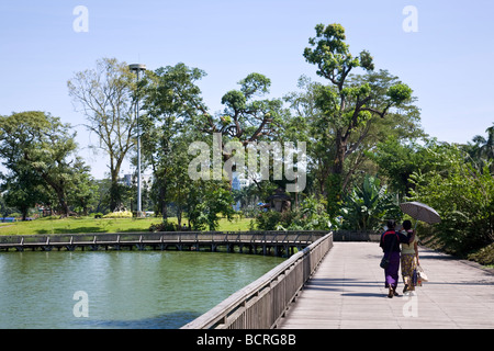 Burmesische paar zu Fuß über die Fußgängerbrücke. Kandawgyi See. Yangon. Myanmar Stockfoto