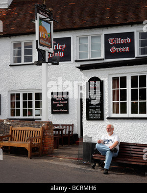 Ein Mann einen Drink außerhalb der Gerste Mähen Gastwirtschaft, Tilford, Farnham, Surrey, England, UK. Stockfoto