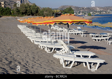 Liegestühle und Sonnenschirme am Sandstrand in Lothiarika in der Nähe von Lardos Rhodos-Dodekanes-Inseln Griechenland Stockfoto