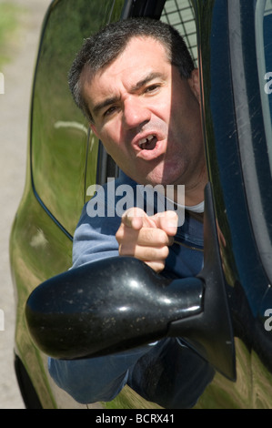 Männliche Fahrer schreiend aus dem Fahrersitz eines Autos in einem Anfall von Wut im Straßenverkehr Stockfoto