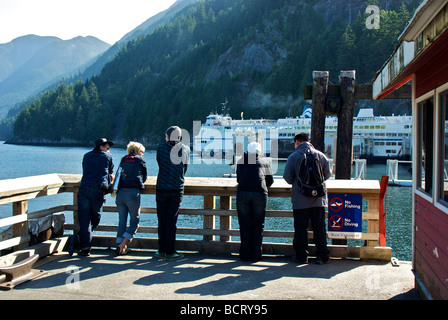 Touristen genießen die spektakuläre Aussicht auf Berge Wasser vom Pier entfernt, mit Blick auf Horseshoe Bay ferry terminal Stockfoto