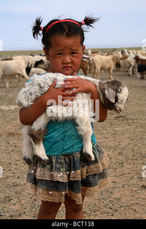 Porträt des mongolischen kleines Mädchen hält ein Lamm in den Armen, Mongolei Stockfoto