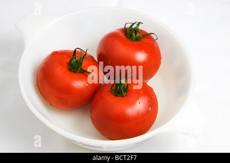 Rebe reife Tomaten in eine Schüssel weiß auf weißem Hintergrund Stockfoto