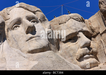 Arbeitnehmer über Teddy Roosevelt richten Sie Seile und Halterungen für Wartungsarbeiten am Mount Rushmore National Memorial. Stockfoto