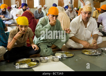 Sikh-Männer eine kostenlose Mahlzeit serviert in der Gemeinschaftsküche im The Golden Tempel (Sri Harmandir Sahib) Amritsar. Indien. Stockfoto