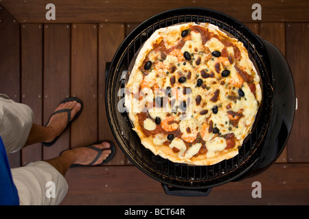 Das Backen einer Pizza Dank Grill legen. Anwendbar d ' une Pizza Dans un Grill À Couvercle. Stockfoto