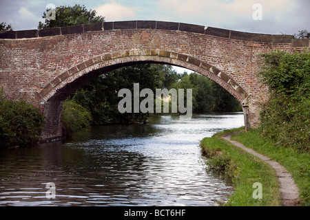 Eine schmale Boot navigiert Bridgewater Kanal entlang und eine gewölbte Brücke unterquert Stockfoto