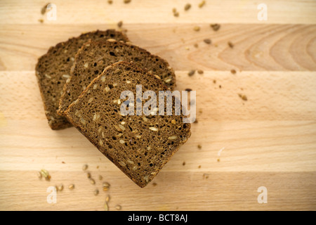 drei Scheiben Vollkornbrot Brown auf Brett gestapelt anzeigen Vögel Stockfoto