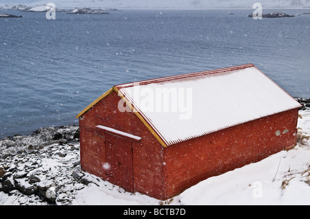 Schnee bedeckte Boot am Ufer des Selfjord im Winter, in der Nähe von Fredvang, Moskenesoy, Schuppen Lofoten Inseln, Norwegen Stockfoto