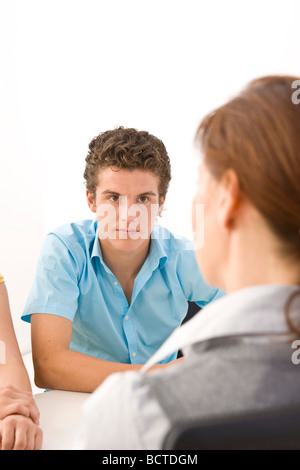 Zwei Jugendliche sitzen an einem Tisch mit ihrem trainer Stockfoto