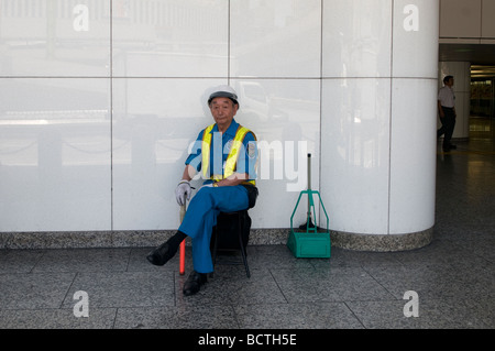 Ein Straßenkehrer macht eine Pause während seines Arbeitstages in Tokio, Japan Stockfoto