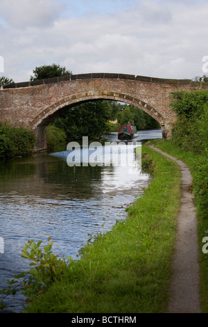 Eine schmale Boot navigiert Bridgewater Kanal entlang und eine gewölbte Brücke unterquert Stockfoto