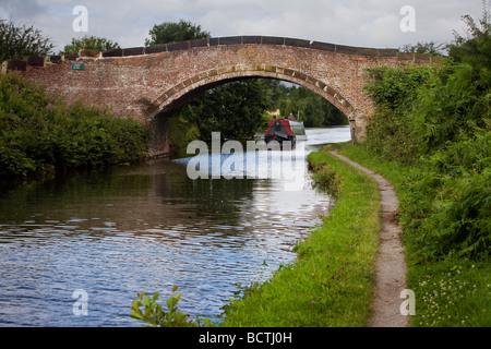 Eine schmale Boot navigiert Bridgewater Kanal entlang und eine gewölbte Brücke unterquert Stockfoto