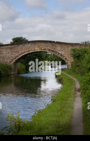 Eine schmale Boot navigiert Bridgewater Kanal entlang und eine gewölbte Brücke unterquert Stockfoto