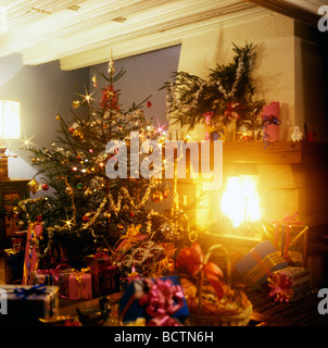 WEIHNACHTSGESCHENKE UNTER DEM BAUM UND KAMIN Stockfoto