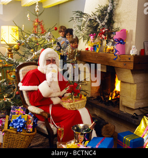 3 NEUGIERIGE KINDER BEOBACHTEN DEN WEIHNACHTSMANN BEIM KEKSE AM BRENNENDEN KAMIN, GEMÜTLICHES WOHNZIMMER, INNENEINRICHTUNG Stockfoto