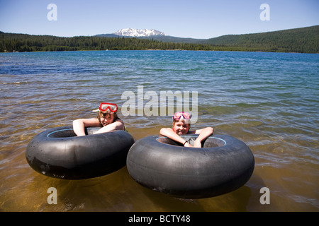 Zwei Teen ager schweben in Schläuche in Mondsichelsee während des Sommers in der Cascade Mountains of Central Oregon Stockfoto