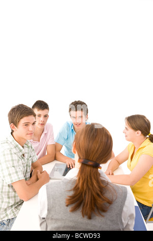 Gruppe von Jugendlichen, die mit ihrem Trainer an einem Tisch sitzen Stockfoto