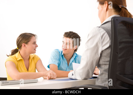 Zwei Jugendliche sitzen an einem Tisch mit ihrem trainer Stockfoto