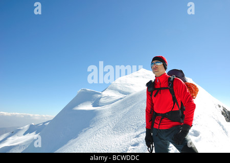 junger Mann mit technischen alpine Ausrüstung und Ausstattung Pose auf dem Gipfel eines Berges in den italienischen Alpen nach Eisklettern Stockfoto
