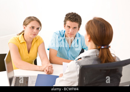 Zwei Jugendliche sitzen an einem Tisch mit ihrem trainer Stockfoto