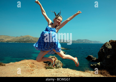 Hübsches junges Mädchen springen in der Luft am Meer in Griechenland Stockfoto