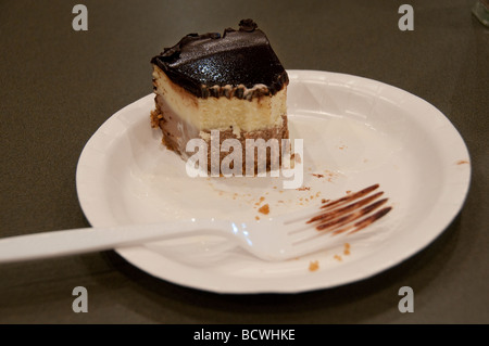 Schokoladen-Käsekuchen auf Pappteller teilweise gegessen. Stockfoto