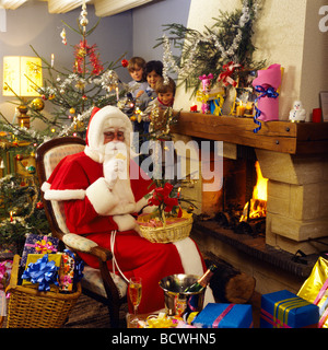 HERR 3 KINDER BEOBACHTEN WEIHNACHTSMANN ESSEN COOKIES Stockfoto