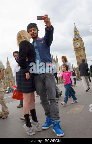 Eine hübsche junge blonde Mädchen küsst ihren asiatischen Freund, als er sie vor Big Ben und den Houses of Parliament Fotos Stockfoto