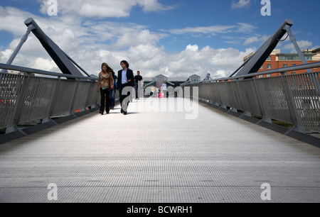 Menschen, die zu Fuß über die Sean Ocasey Brücke über den Fluss Liffey in die Dublin Stadt neuentwickelten docklands Stockfoto