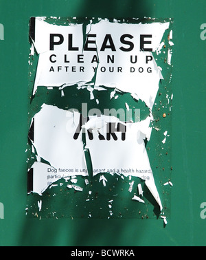 verwitterte Aufräumen nach Ihrem Hund Schild auf grünem Hintergrund Stockfoto