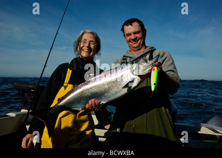 Glücklich weibliche Angler mit ihrem Führer hält frisch gefangen Pacific Chinook Lachs von Ucluelet v. Chr. Stockfoto