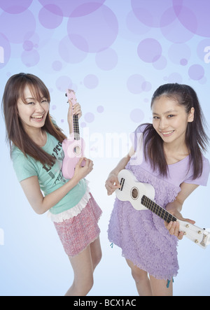 Junge Frauen spielen der ukulele Stockfoto