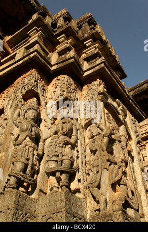 Ein Hindu-Gott und Göttin unter Schnitzereien im Hoysaleswara Tempel von Halebid, Indien. Stockfoto