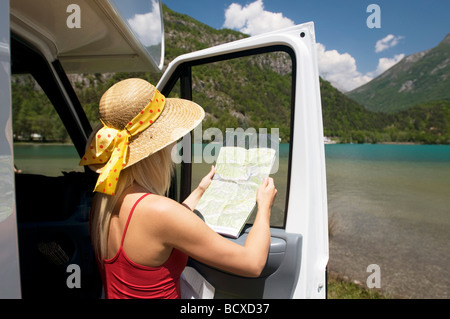 junge Frau, die im Besitz einer Karte Stockfoto