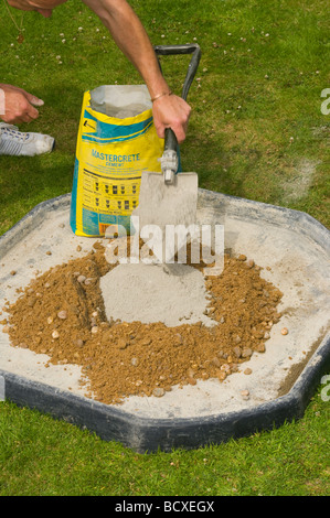 Handyman Ballast mit einer Schaufel Zement hinzufügen Stockfoto