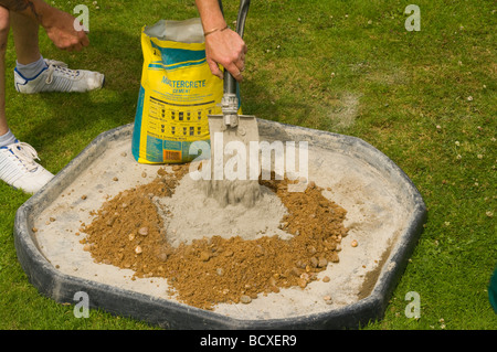 Handyman Ballast mit einer Schaufel Zement hinzufügen Stockfoto