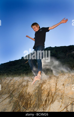 Springen am Sandstrand Stockfoto