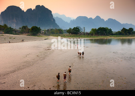 Frauen waten Nam Song River in Vang Vieng, Laos Stockfoto