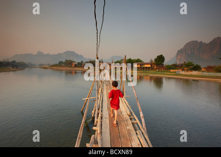 ein Junge, der Brücke über den Nam Song River in Vang Vieng, Laos Stockfoto