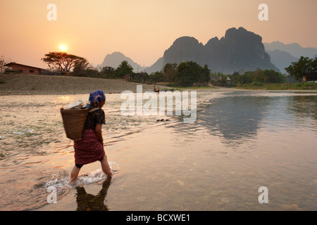 eine Frau fording Nam Song River in Vang Vieng, Laos Stockfoto